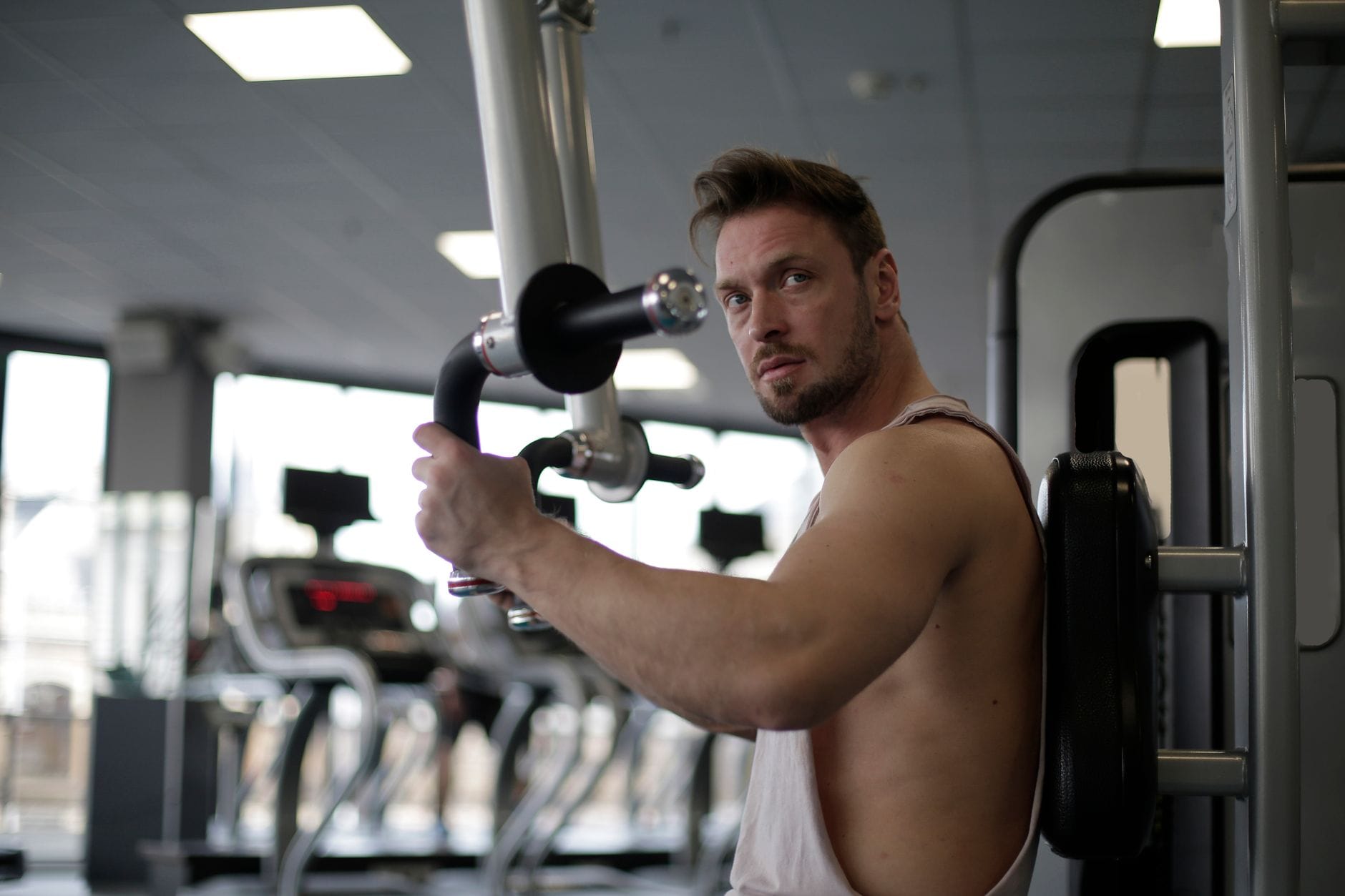 Skupiony mężczyzna ćwiczący biceps na siłowni
