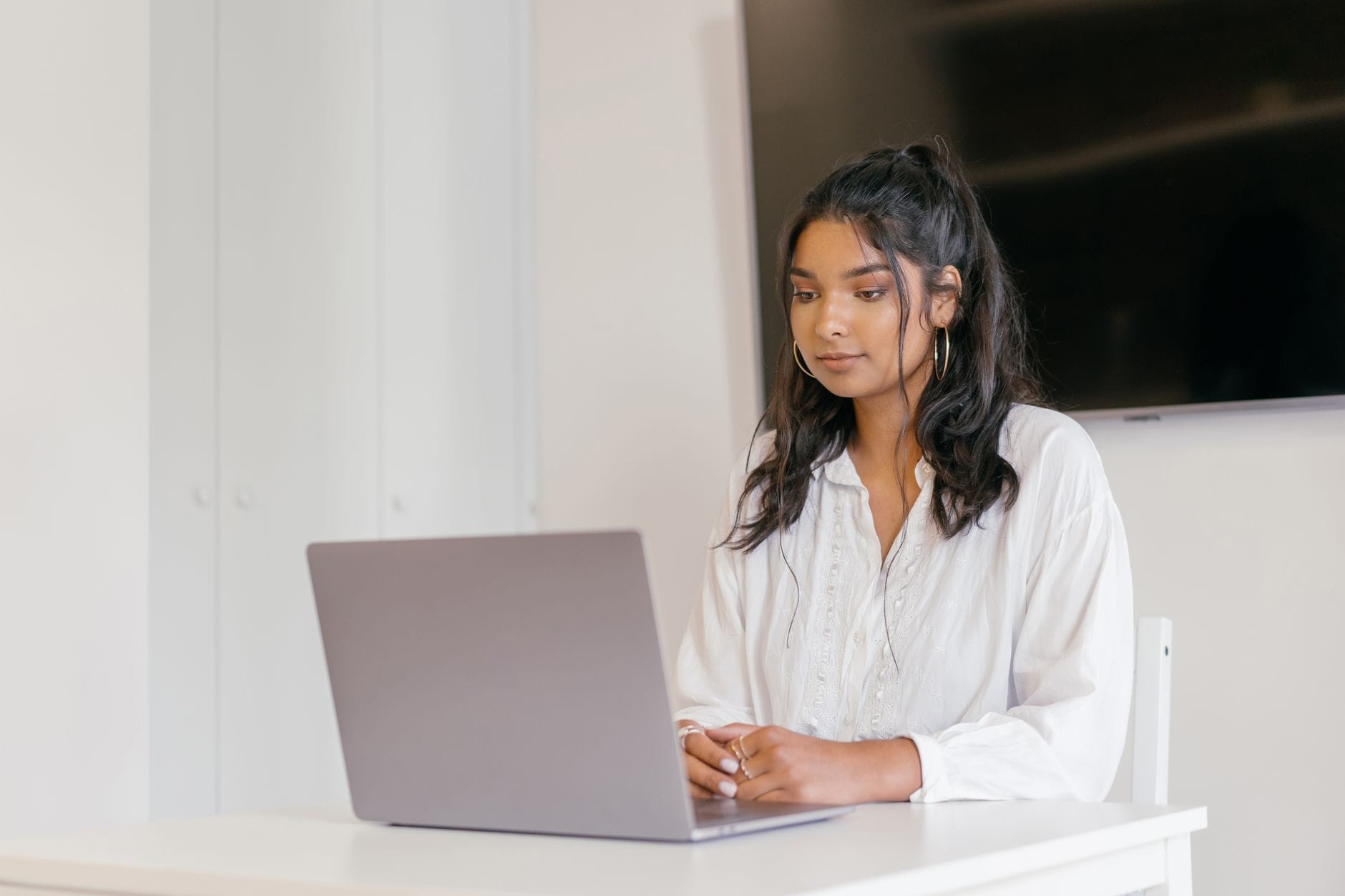 Jak kursy online zmieniają rynek pracy i czego oczekują dziś pracodawcy Młoda kobieta uczy się online przy laptopie w nowoczesnym wnętrzu